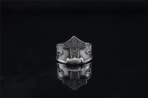 Macro shot of Viking Mjolnir ring with vintage embossed patterns on a black background