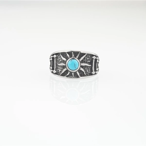 Vintage stainless steel ring with turquoise stone and sunburst pattern on white background