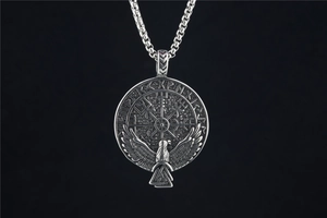 Macro view of Viking compass pendant with eagle and runes on black background