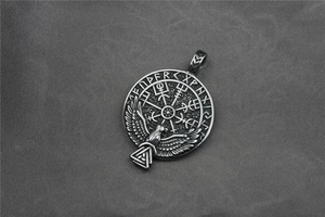 Detail of Viking compass pendant with rune letters and eagle in relief on steel