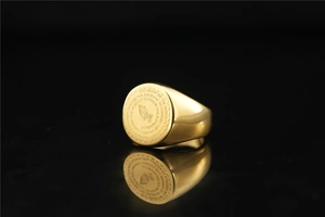 Close-up of golden signet ring for men with prayer hands and Serenity Prayer engraving