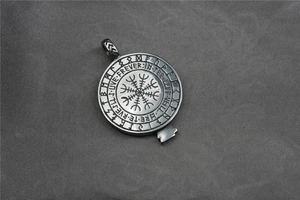 Macro detail of vintage steel eagle pendant with Nordic runes and text engraving