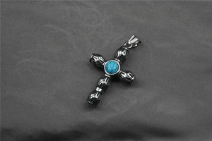 Détail du pendentif croix rétro en titane avec incrustation turquoise et motifs tribaux