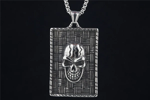 Gros plan du pendentif punk carré en acier avec crâne 3D et texture tressée fine