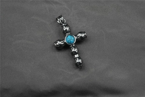 Gros plan d'un pendentif croix vintage avec turquoise incrustée et détails gothiques