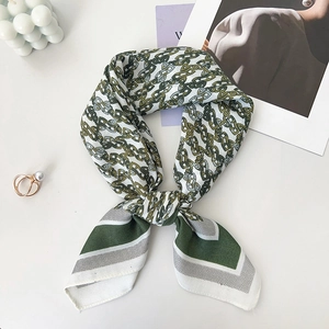 Detailansicht des grün bedruckten Seidenschals mit Satin-Finish und eleganter Textur