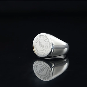 Polished silver signet ring featuring engraved praying hands and serenity prayer text