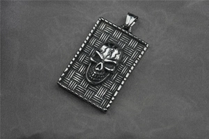 Détail macro du pendentif crâne punk avec texture tissée sur plaque d'acier inoxydable 3D