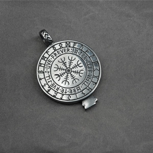 Vintage steel pendant with eagle and Vegvisir symbol on gray textured background