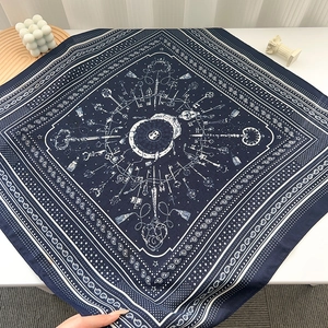 Flat lay of navy blue square silk scarf with vintage clock and paisley patterns
