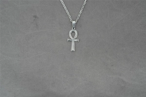 Dettaglio macro del ciondolo chiave Ankh in acciaio inossidabile lucido con finitura a specchio