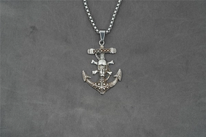 Detail of vintage silver anchor skull pendant with crossbones and link chain for men