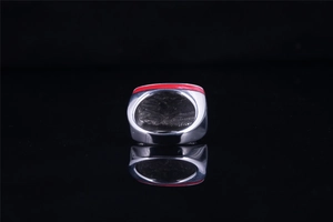 Détail d'une bague en acier titane avec ligne en émail rouge et reflet sur fond noir