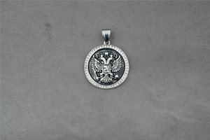 Détails macro du pendentif rond vintage avec relief d'aigle et zircons sertis en pavé