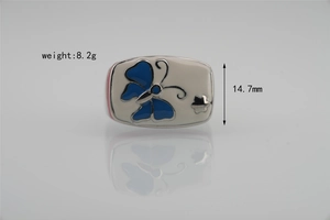 Détail macro du charm en émail avec motif papillon bleu et marquage de poids 8,2g