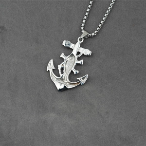 Mens stainless steel anchor pendant necklace with box chain on grey fabric background