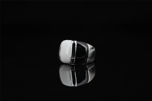 Macro shot of black and white geometric enamel inlay on polished titanium steel ring