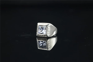 Macro-opname van zilveren titanium stalen ring met blauwe zirkoon en Grieks patroon