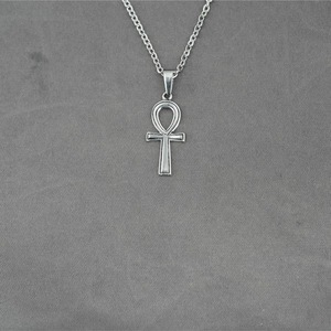 Collana con pendente croce Ankh in acciaio inossidabile argento su sfondo in tessuto grigio