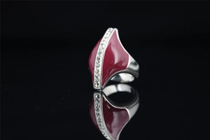 Macro shot of polished silver steel ring with asymmetrical red enamel and small crystals