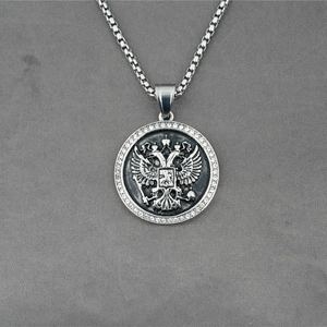 Collier à pendentif rond argenté avec emblème d'aigle à deux têtes et pierres sur chaîne box