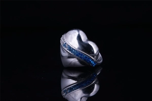 Macro view of vintage silver heart ring with inlaid blue and white crystals