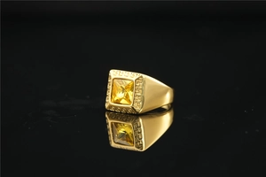 Detail van gouden herenring met vierkante gele edelsteen en Griekse sleutelpatronen