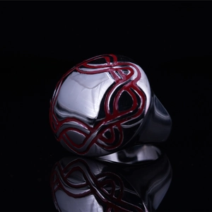 Vintage stainless steel ring with red geometric pattern on black reflective background