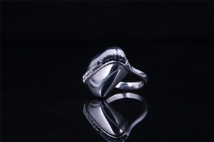 Macro view of sculptural steel ring with black and white zircon side inlays on black mirror