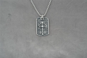Detailansicht des Vintage-Silber-Militäranhängers mit Kreuz- und Lilien-Gravur im Retro-Stil