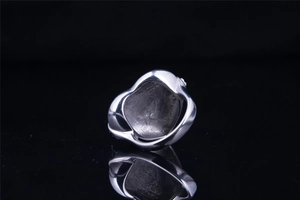 Macro shot of polished silver vintage heart ring with unique 3D hollow structure and reflection