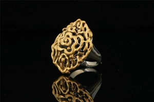 Macro view of vintage titanium steel cocktail ring with gold hollow floral pattern