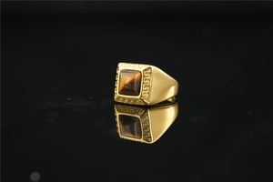 Detailopname van gouden zegelring voor heren met tijgeroog en Grieks patroon
