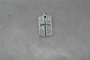Makroansicht des Vintage Silber Stahl Anhängers mit Kreuz und schwarzen Zirkonia