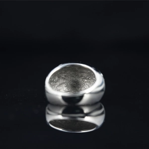 Polished silver titanium steel ring with textured inner surface on black background