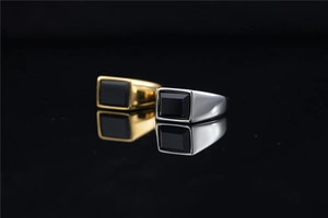Macro shot of gold and silver titanium rings with rectangular black gemstone inlay