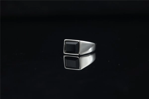 Macro view of men's silver stainless steel ring with rectangular black gemstone inlay