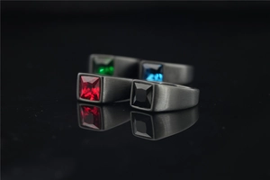 Detail view of four men's square gemstone rings with black brushed stainless steel finish