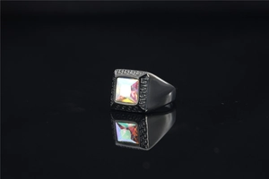 Detail van zwarte roestvrijstalen ring met regenboog edelsteen en Grieks motief