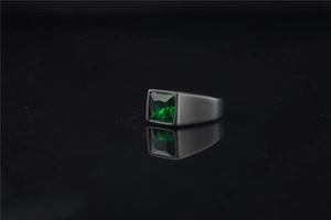 Detail of emerald cut green gemstone on black brushed titanium men's signet ring