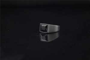 Macro detail of men's matte black titanium ring featuring a square black gemstone inlay