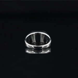 Polished titanium steel ring with rectangular black gemstone for men on black surface
