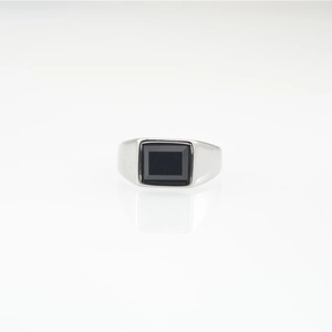 Men's titanium steel ring with rectangular black gemstone on white reflective surface