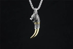 Detailed view of vintage silver dragon head pendant with polished golden tooth accent