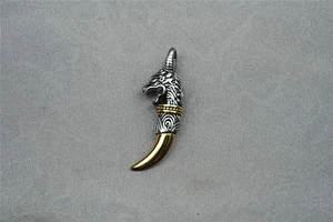 Detailed close-up of a vintage wolf head pendant with silver and gold two-tone finish