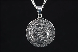 Macro view of vintage silver Viking pendant with Ouroboros snake and Rune circle