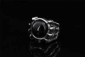 Macro detail of gothic claw ring holding a polished black onyx stone in silver setting