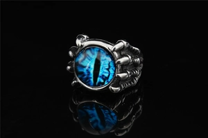 Macro shot of gothic dragon claw ring featuring a detailed blue evil eye and aged steel