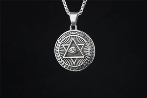 Gros plan détaillé du pendentif Œil de la Providence en acier vintage avec texte gravé