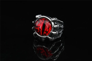 Macro shot of silver eagle claw holding a red dragon eye in punk gothic style